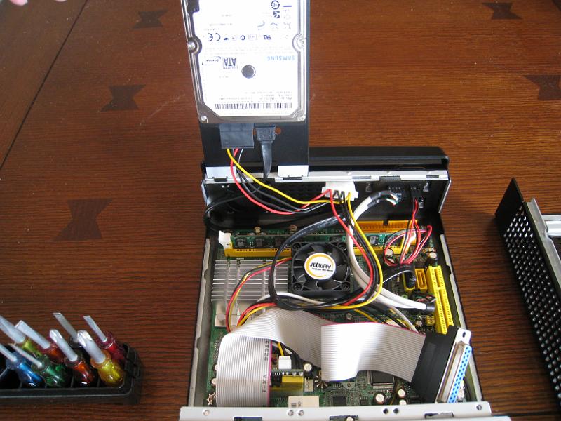 IMG_3686.JPG - Hood up.  Note parallel port DB25 cable that plugs into motherboard header.  The IRLP board interfaces to computer via the parallel port.  The DC/DC power supply is partly visable just to the right of the parallel port header connection.  The power supply is integrated in the connector to the motherboard's power supply input.  It provides power for the motherboard, HD and IRLP board.